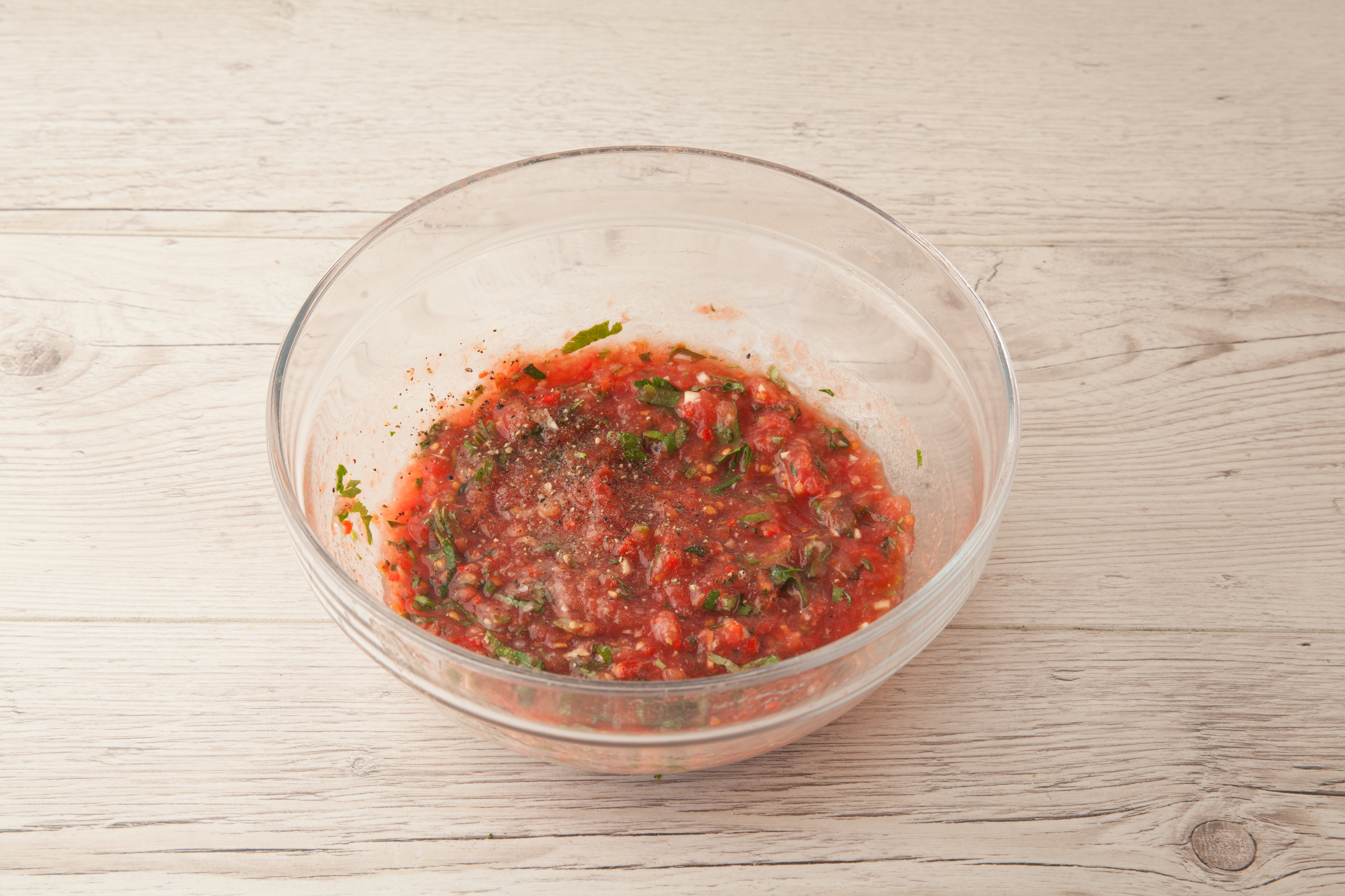 Смешайте помидорное пюре, чеснок, зелень и чили, добавьте соль и черный перец, влейте 2 ст. л. оливкового масла и хорошо перемешайте.
